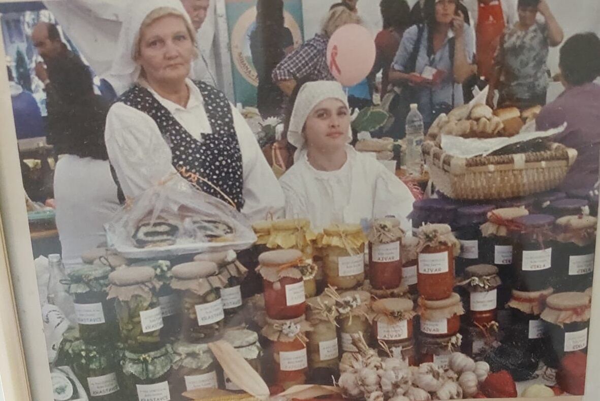 Dvije žene u narodnoj nošnji iza štanda